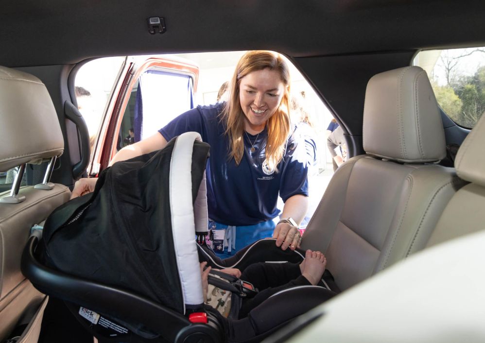 A USA Health employee checks an infant's car seat.