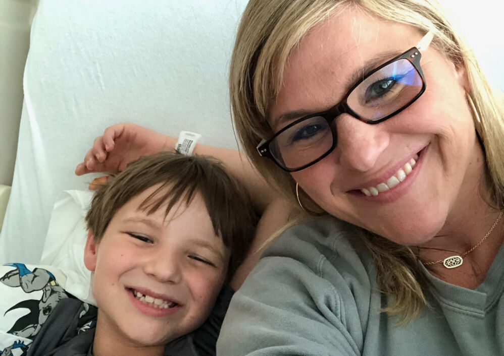 A mother and her son smile for a selfie.