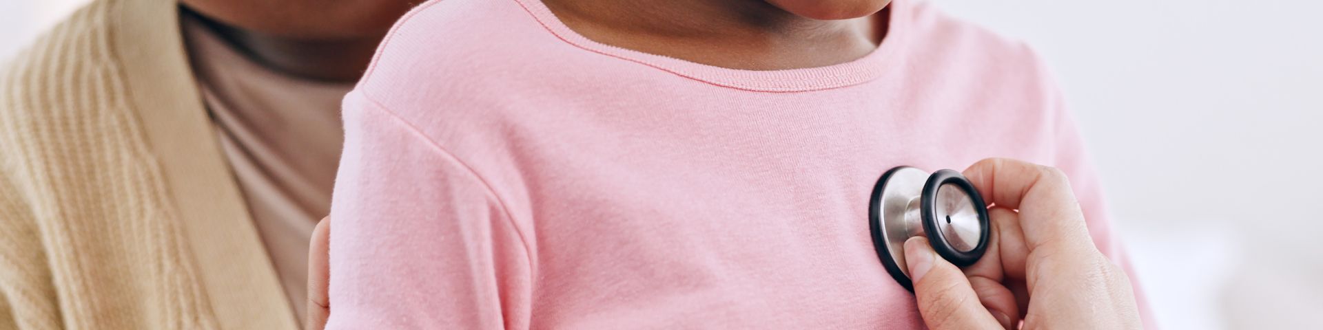 A provider listens to a child's chest using a stethoscope.