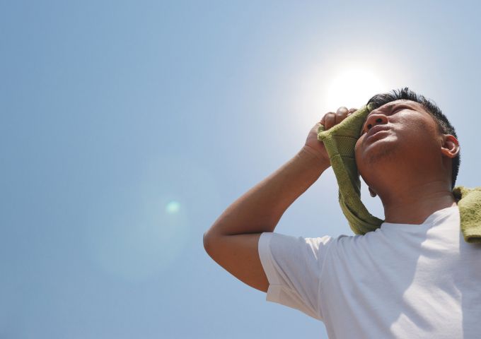 A man stands outside in the heat