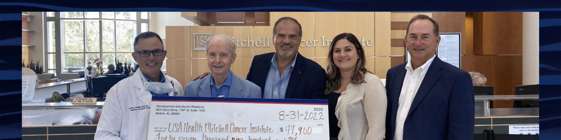 Martin Heslin, M.D., left, director of the USA Health Mitchell Cancer Institute, receives donations totaling $47,900 from Abraham A. Mitchell, second from left; and K.C. Constantine, third from left, president of Manning Inc. Piggly Wiggly. Also pictured are David White, right; and Maya De Andrade.